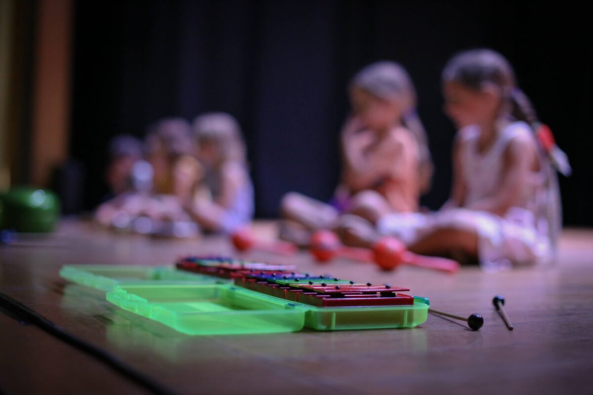 Les enfants de l'éveil musical assis sur scène derrière leurs instruments