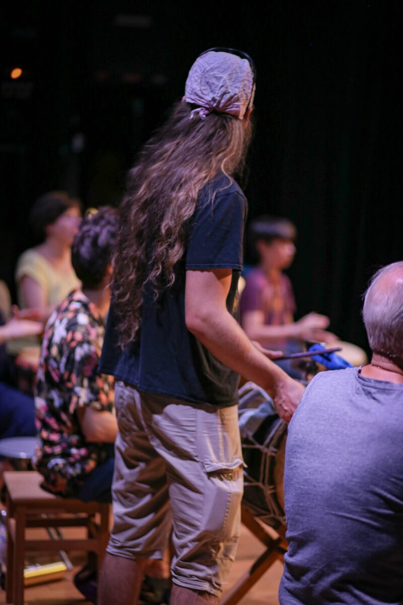 Un percussionniste debout mène le groupe, baguette à la main